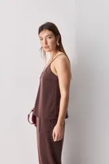 Top negro de breteles finos con escote en V y diseño minimalista, confeccionado en tela fluida y suave.
