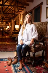 Camisa blanca de algodón con cuello mao, corte amplio, mangas largas abullonadas con puños abotonados y detalle de canesú con pliegues en el pecho.