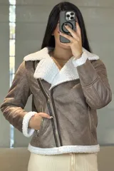 Campera tipo gamulán de cuero sintético negro con interior y solapas de corderito blanco. Presenta cierre frontal cruzado y bolsillos laterales con cierre.
