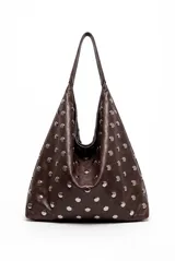 Cartera tipo hobo de cuero sintético marrón, decorada con tachas metálicas plateadas en toda su superficie. Cuenta con asa de hombro integrada.
