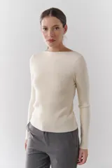 Buzo de morley color crema, con cuello bote y manga larga. Presenta un diseño de punto acanalado y un detalle de franja horizontal en el pecho.