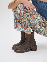 Bota tipo chelsea de cuero vacuno color marrón, con paneles elásticos laterales, plataforma y taco cuadrado de altura media.