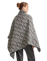 Ruana de Jones New York con estampado animal print en tonos blanco y negro. Presenta un diseño envolvente con cuello alto y cierre frontal mediante un botón tipo trenca.