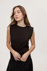 Remera sin mangas negra con cuello redondo y hombros estructurados con hombreras, de corte recto y largo a la cintura.