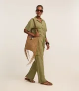 Pantalón largo color verde oliva, de corte pijama, confeccionado en malla orly. Presenta cintura elástica con lazo, bolsillos laterales tipo cargo y corte fluido.