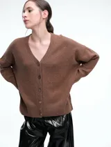 Cardigan de punto color marrón con textura jaspeada, escote en V, cierre frontal con botones y diseño de hombros caídos.