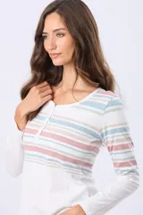 Remera t-shirt de algodón con rayas horizontales en tonos pastel (lila, beige, azul claro y azul oscuro), cuello redondo con botones delanteros y aberturas laterales.