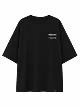 Remera de corte oversize color negro con estampa tipográfica minimalista en el pecho y etiqueta pequeña en el ruedo.