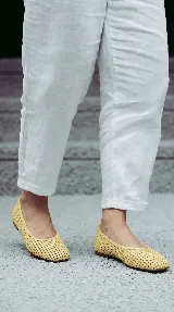 Chatita de cuero color off-white, con diseño calado en toda su superficie y punta redondeada.