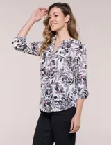 Blusa de gasa estampada de la marca Zac & Rachel, con diseño floral en tonos azul, celeste y verde sobre base blanca. Presenta escote en V con abertura y botones frontales, y mangas largas de largo regulable con presilla.