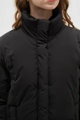Campera puffer negra con cuello alto, cierre frontal oculto y puños tejidos acanalados. Diseño acolchado con bolsillos laterales.