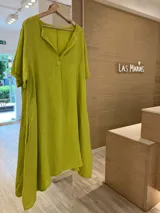 Vestido de lino color verde lima, estilo túnica, con escote en V, manga corta, bolsillos laterales y largo asimétrico.