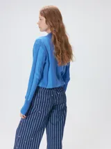 Sweater de punto con diseño de rayas verticales en tonos negro y gris oscuro. Presenta cuello alto tipo polera, mangas largas con puños ajustados y ruedo elástico. Incluye un pequeño bordado en color rojo en el pecho.