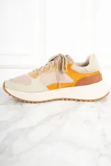 Zapatillas urbanas de cuero color beige, con detalles en amarillo, naranja y marrón.