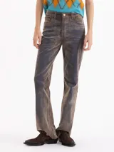 Pantalón de corte oxford con silueta ajustada hasta la rodilla y botamanga relajada. Confeccionado en tela Denim Velvet con textura aterciopelada y acabado de jean lavado en tono marrón.