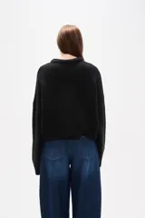 Sweater de tejido de punto color negro, con cuello redondo a la base, mangas largas y diseño holgado.