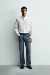 Camisa de corte regular fit confeccionada en tejido de algodón con efecto lavado. Presenta cuello abotonado, manga larga con puños abotonados, bolsillo en el pecho y cierre frontal con botones.