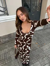 Vestido largo de viscosa con estampado abstracto en tonos marrón y blanco, de corte ajustado, escote redondo amplio y mangas largas.