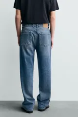 Pantalón de jean con corte recto desde la cadera y leve ensanchamiento en el bajo. Presenta tiro medio, cinco bolsillos, cierre frontal con cremallera y botón, y un acabado con efecto lavado.