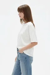 Remera negra de algodón con cuello redondo, mangas cortas y diseño holgado, decorada con líneas verticales de strass.