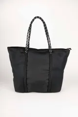 Bolso tipo tote color verde militar con múltiples correas horizontales y verticales. Tiene doble asa de soga trenzada y cierre superior con cremallera.