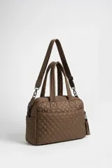 Cartera Rapsodia tipo morral acolchado color marrón con costuras romboidales, doble asa de mano y correa larga ajustable. Cuenta con dos bolsillos frontales con cierre y llavero colgante con pompones.