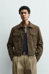 Cazadora cropped fit de efecto piel en color verde militar, con cuello solapa, manga larga con puño abotonado, bolsillos frontales de plastrón con solapa y cierre de botonadura.