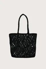 Bolsa tipo tote tejida en crochet con diseño de diamantes en color negro. Cuenta con doble asa superior trenzada y un detalle de etiqueta de cuero sintético color suela colgando de una de las asas.