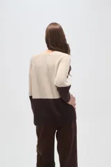 Sweater de punto con diseño color block, combinando azul marino en la parte superior y celeste en la inferior. Presenta cuello redondo a la base y mangas largas con terminación en puño.