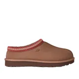 Pantuflas UGG modelo Tasman II, confeccionadas en gamuza color tostado. Presentan un diseño sin cordones con detalle de trenza decorativa en el borde superior y suela de goma resistente.