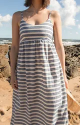 Vestido largo tipo solera con breteles finos, diseño de rayas horizontales en tonos azul y blanco, confeccionado en tejido ligero.