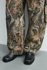 Zueco destalonado de cuero negro con hebilla metálica ajustable en el empeine, plantilla de cuero y suela plana con pequeño tacón.