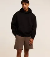 Bermuda masculina de algodón con felpa, color negro, corte slim fit. Presenta cintura elástica con cordón ajustable, bolsillos y etiqueta aplicada.