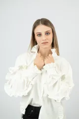 Camisa blanca de cuello mao con volados, mangas largas con puños ajustados y corte clásico.