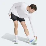 Short deportivo 2 en 1 Adidas con calza interior integrada. Presenta un diseño estampado con efecto spray en tonos grises y negros, cintura elástica con cordón de ajuste y logo de la marca en el lateral. Incluye bolsillos funcionales y tecnología Formotion para mayor libertad de movimiento.