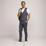 Traje de tres piezas color gris con patrón de cuadros, compuesto por saco con solapas de muesca, chaleco abotonado y pantalón de vestir de corte recto.
