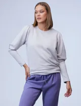 Buzo gris claro de jersey, marca Nanette, con cuello redondo y mangas largas abullonadas con detalle de pinzas en los hombros.