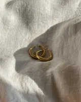 Par de aros tipo argolla con diseño irregular y textura orgánica, acabado en tono dorado.