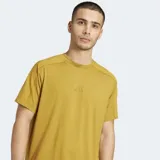 Remera deportiva Adidas de manga corta y cuello redondo, color mostaza/amarillo ocre, con un pequeño logo Adidas en relieve en el pecho. Presenta costuras reforzadas en los hombros.