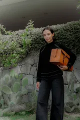 Buzo de punto color blanco con cuello alto y detalles de pespuntes decorativos en color negro en las costuras de los hombros, puños y ruedo.