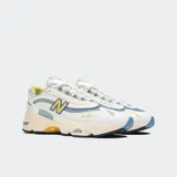 Championes urbanos New Balance modelo 1000, color blanco con detalles en celeste y amarillo, confeccionados en cuero y malla, con logo "N" característico en los laterales y entresuela ABZORB.