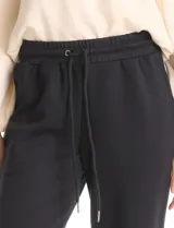 Jogger deportivo de corte holgado, con cintura elástica y lazo de ajuste, bolsillos laterales y puños elásticos en los tobillos.