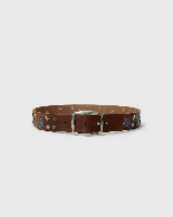Cinturón de cuero negro con hebilla metálica plateada, decorado con tachas y apliques metálicos en forma de estrellas de distintos tamaños.
