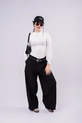 Pantalón de vestir negro de corte wide leg, con diseño de inspiración sastrera y costuras verticales frontales. Presenta un calce fluido y tiro alto.