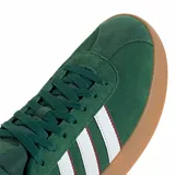 Championes Adidas modelo VL Court 3.0, de color verde con diseño clásico. Presenta la parte superior en gamuza con las icónicas tres tiras laterales en blanco con bordes oscuros. Cuenta con suela de caucho color caramelo y cierre mediante cordones al tono.