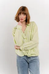 Camisa color crema de algodón con cuello camisero, botones y detalles de encaje en el escote.