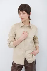 Camisa de estilo casual confeccionada en material tipo gamuza color marrón, con cuello clásico, cierre frontal con botones y costuras a la vista en tono contrastante.