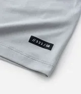 Remera deportiva de hombre con tecnología dry fit, cuello redondo y manga corta. Presenta un diseño liso en color beige con una pequeña etiqueta decorativa en el dobladillo.