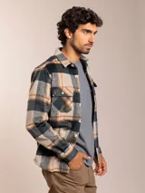 Camisa de franela a cuadros en tonos beige, gris y marrón, con corte regular fit, cuello clásico, cierre de botones frontales y dos bolsillos con solapa en el pecho.