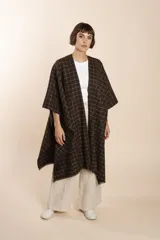 Ruana de lana fina color crudo con terminación envivada.